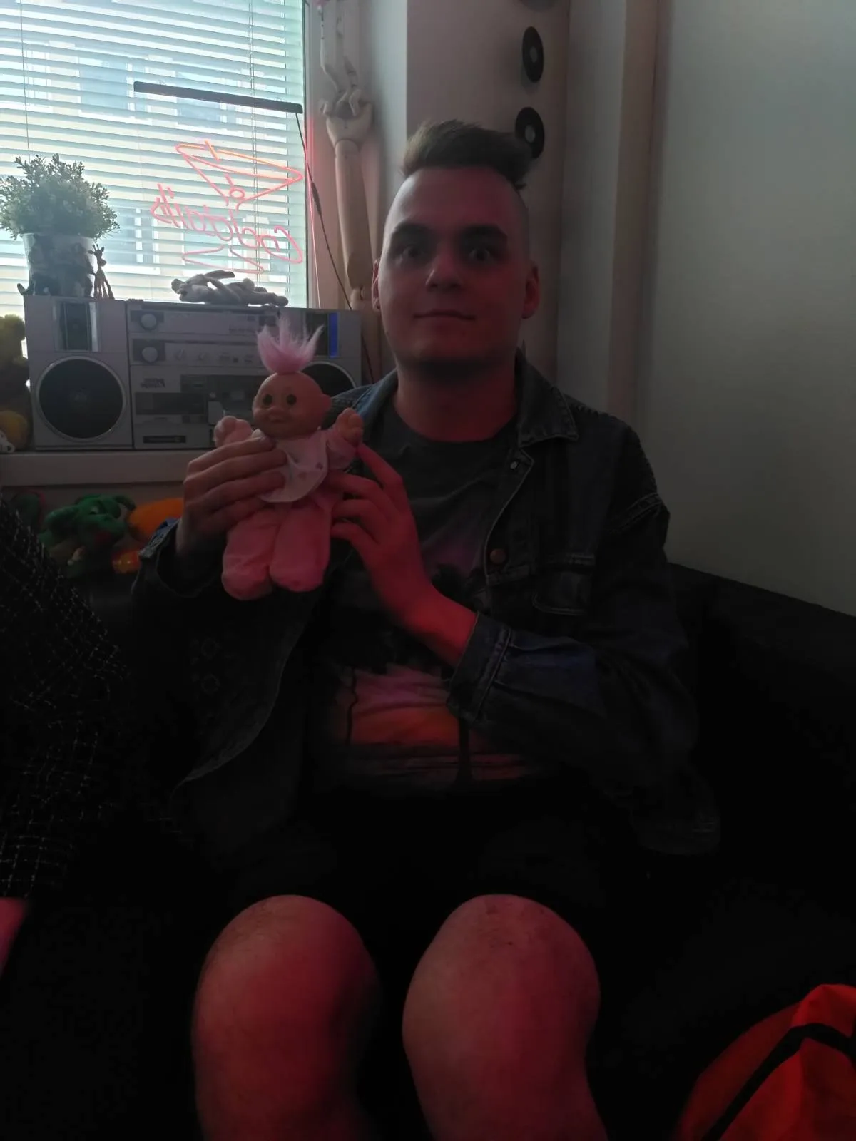 A troll toy holding me in its hands